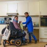 Eine Frau mit Beeinträchtigungen erhält Unterstützung im Haushalt.