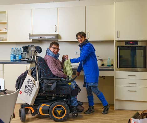 Eine Frau mit Beeinträchtigungen erhält Unterstützung im Haushalt.