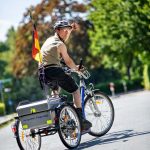 Ein Mann mit Beeinträchtigungen fährt auf seinem Fahrrad durch den Park.