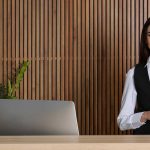 Portrait einer jungen Rezeptionistin am Schreibtisch in der Hotellobby